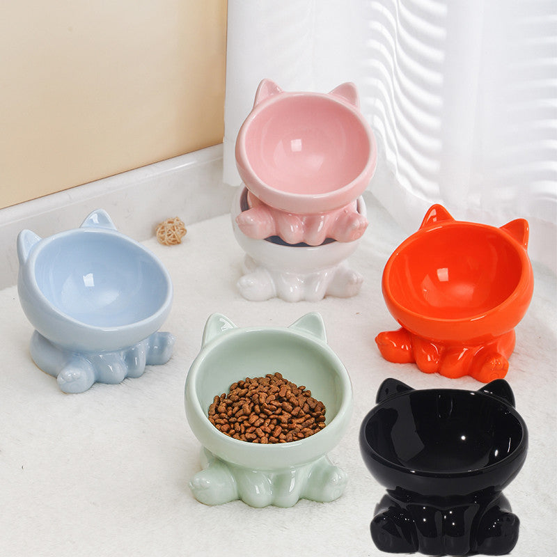 Set of colorful pet bowls shaped like cats on a white surface.