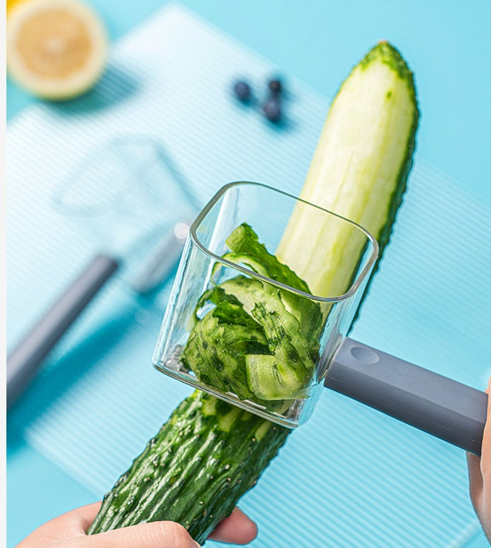 Cucumber being grated into a blender on a blue background